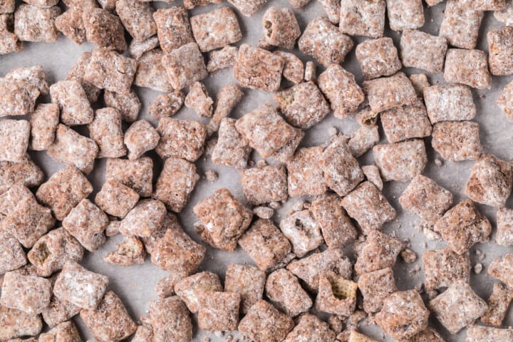 Muddy Buddies on parchment paper closeup.