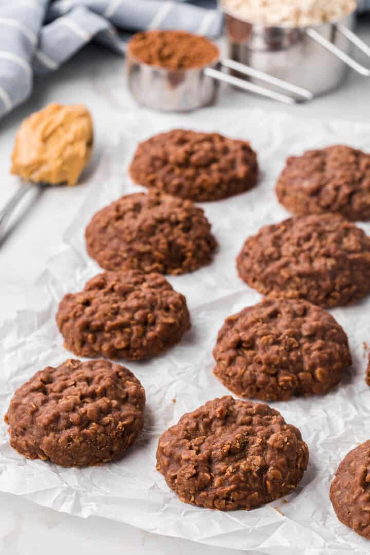 No Bake Cookies on parchment paper with the baking ingredients around it.