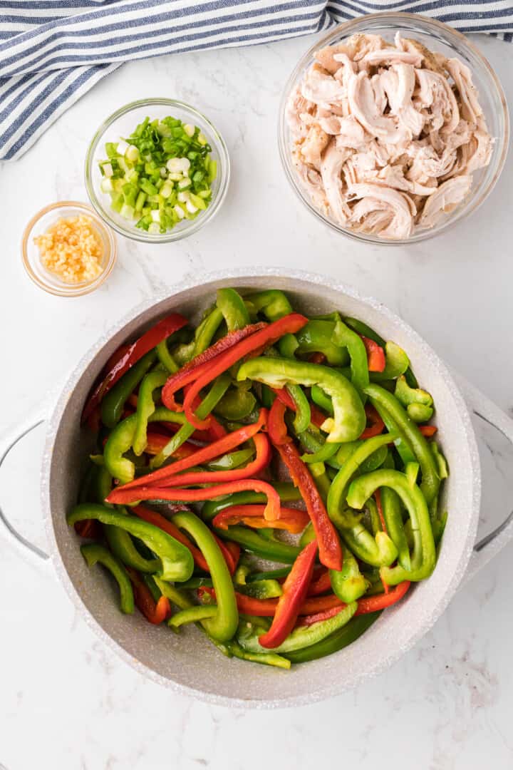 sliced bell peppers in large pot for cooking.