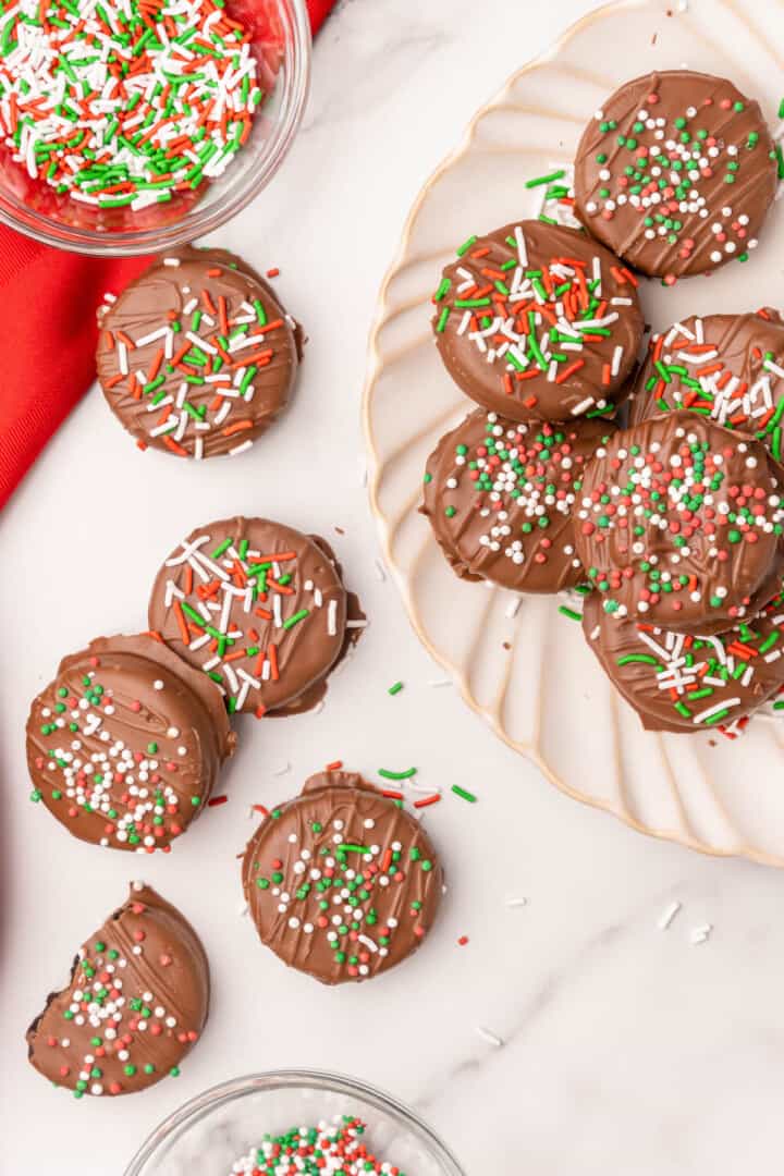 Chocolate Covered Oreos on white plate with sprinkles.