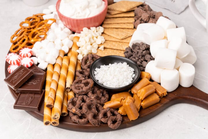 hot chocolate bar items on wooden serving tray.