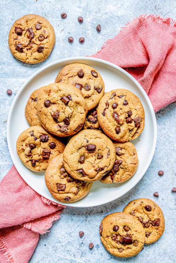 Brown Butter Chocolate Chip Cookies on white plate with red towel underneath.