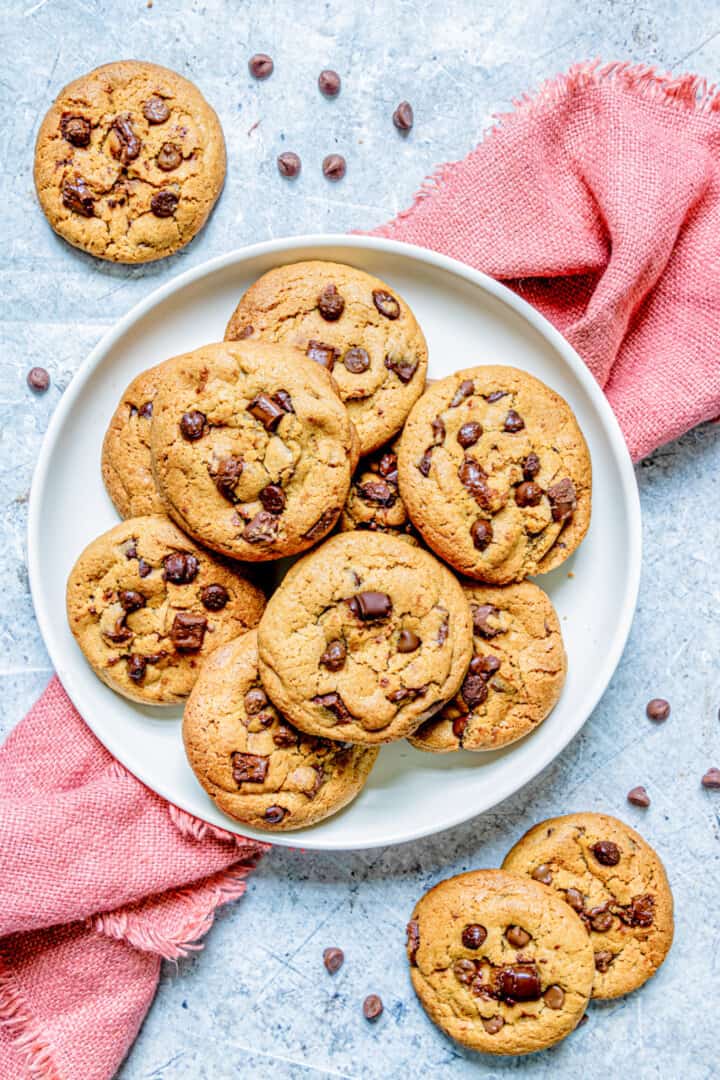 Brown Butter Chocolate Chip Cookies on white plate with red towel underneath.