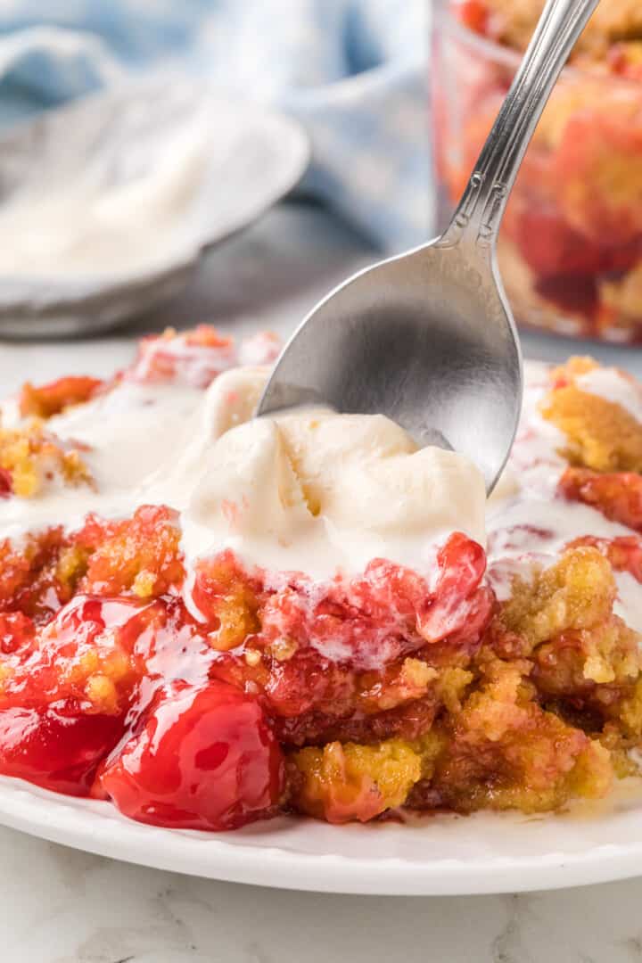 taking a spoonful of the Cherry Dump Cake off the plate.