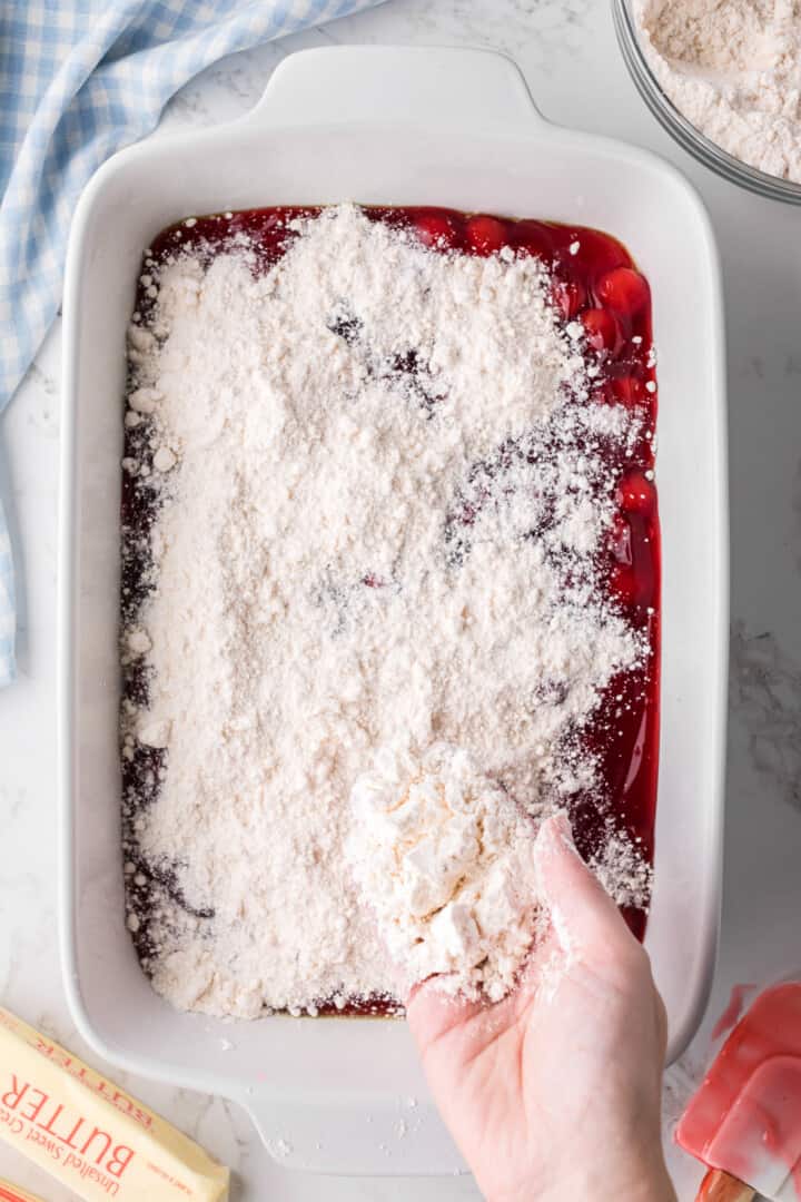 yellow cake mix sprinkled on top of the cherry pie filling.