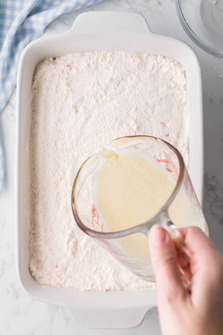 pouring the melted butter on top of the cake.