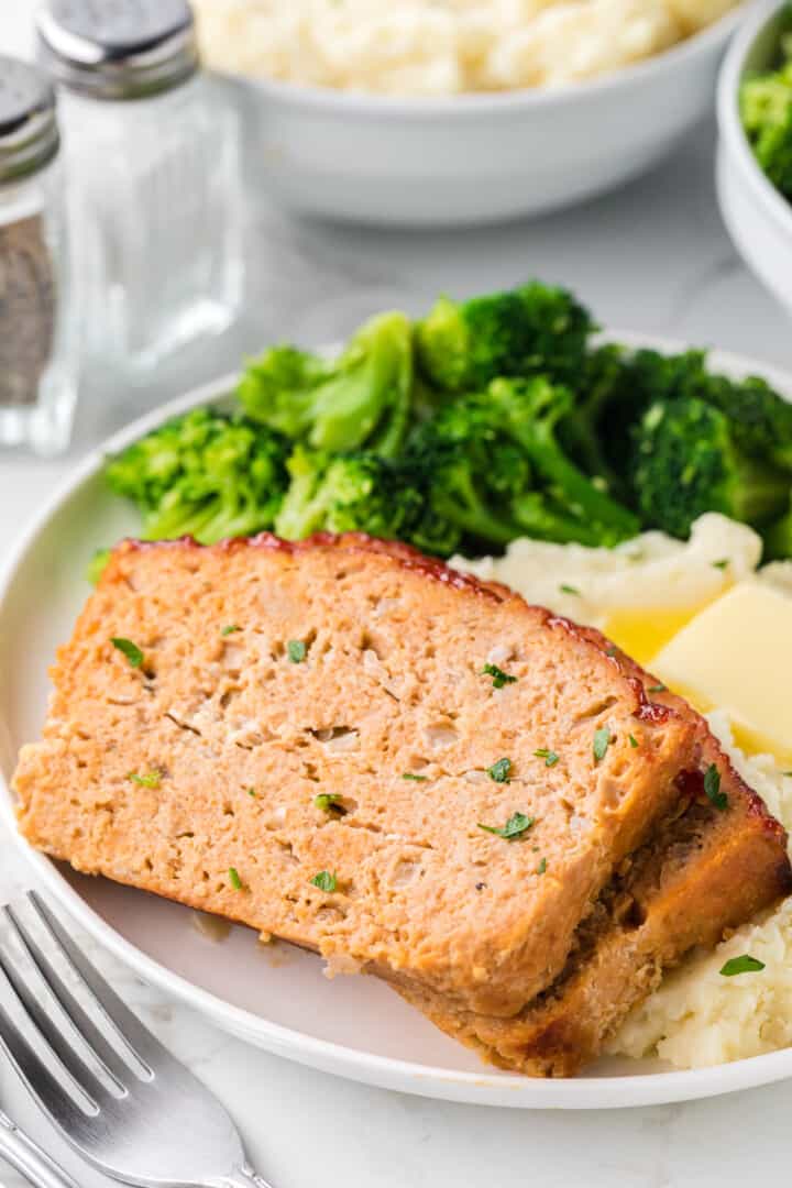 closeup of two slices of the chicken meatloaf dinner on a white plate.