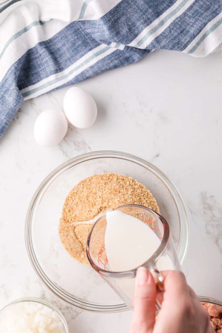 adding milk to the bread crumbs.