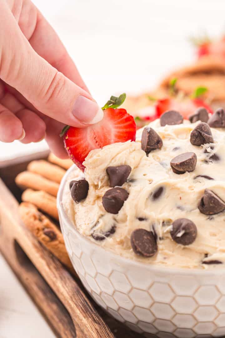 dipping a strawberry into the dip.