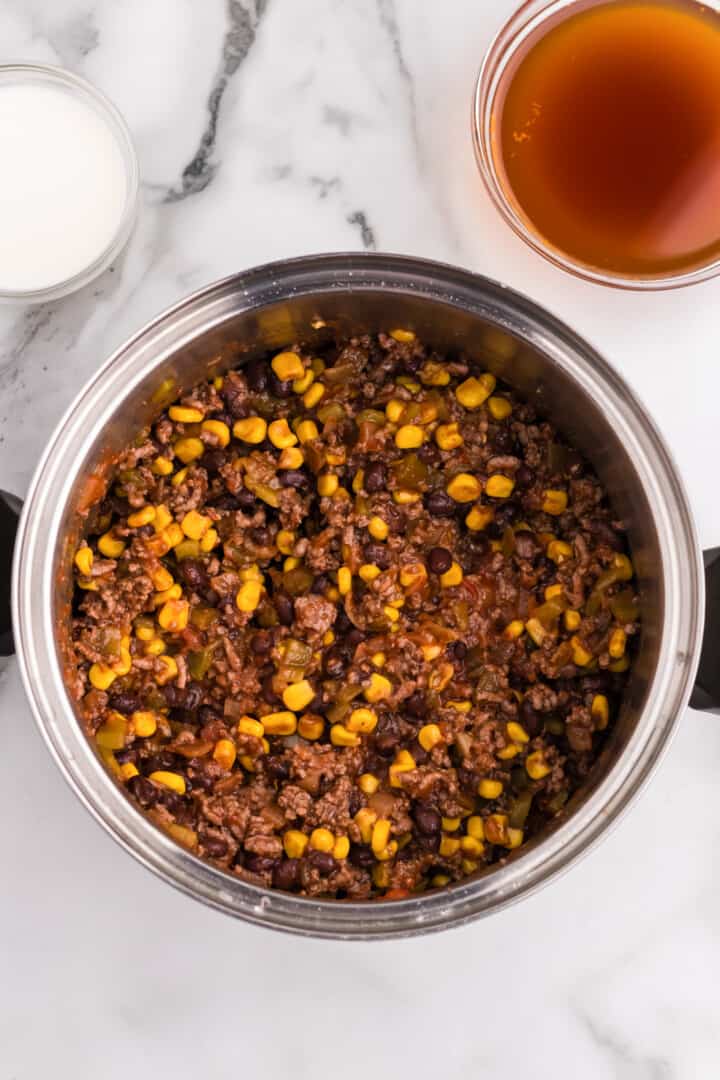 adding the other ingredients to the pot for the soup.