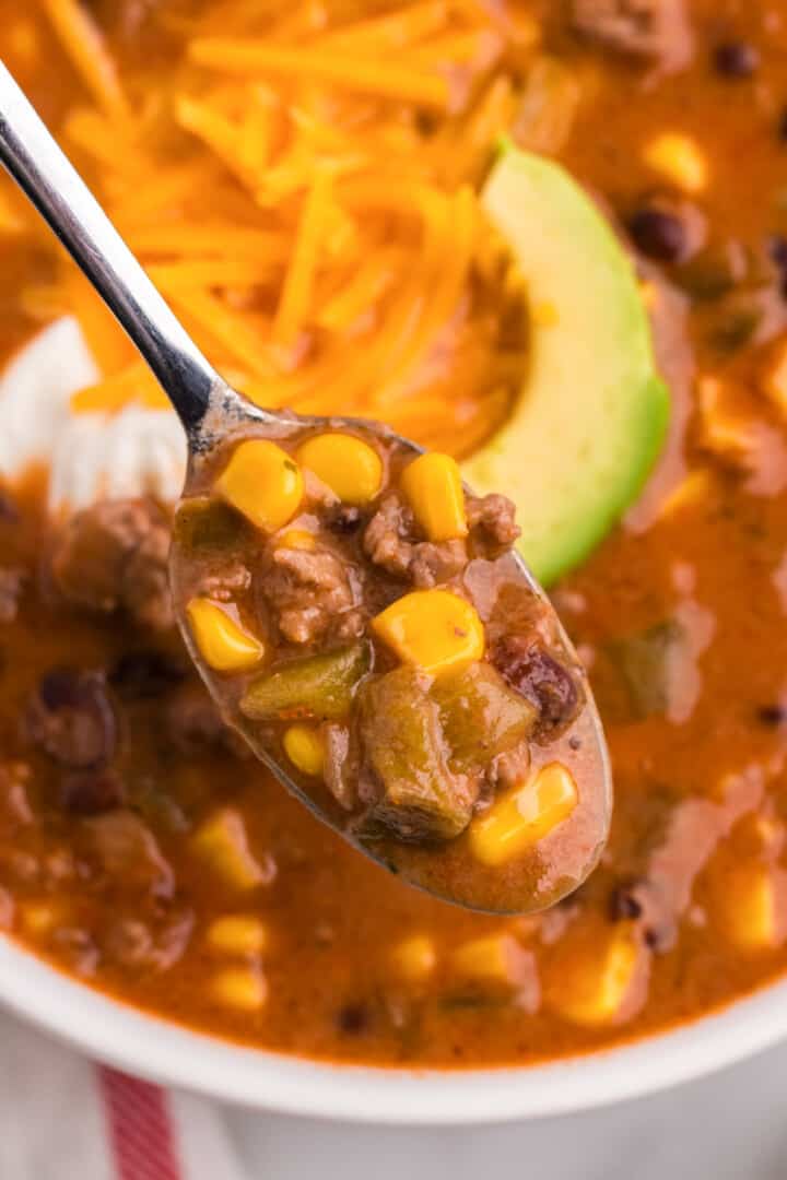 using a spoon to eat the taco soup.