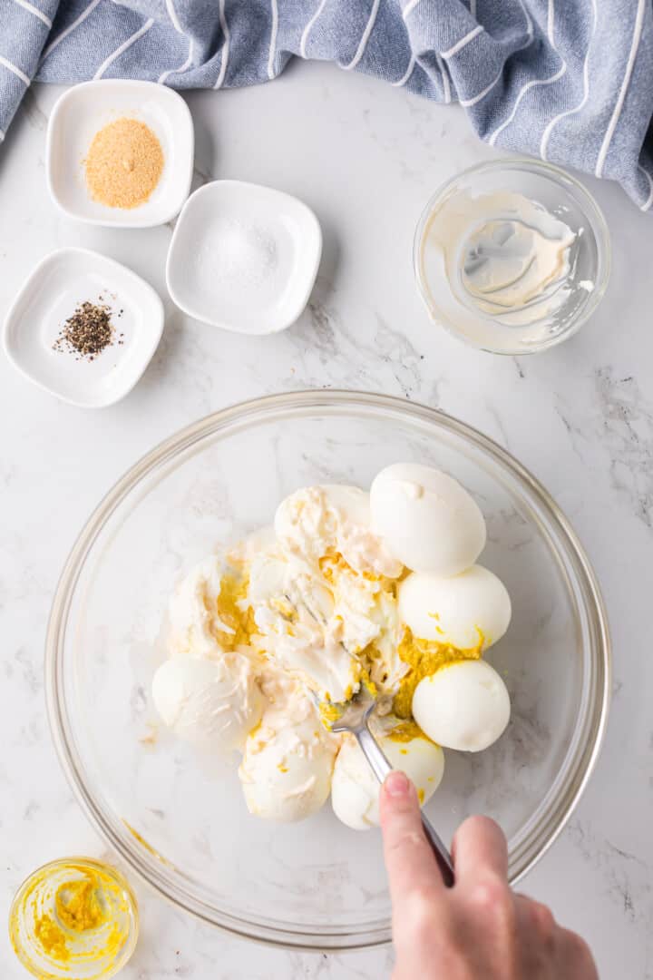 mixing the eggs with the ingredients for the egg salad.