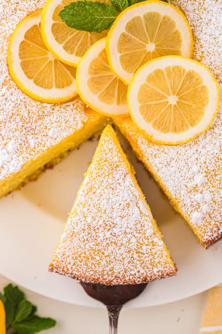 Lemon Ricotta Cake with a slice being served from it.