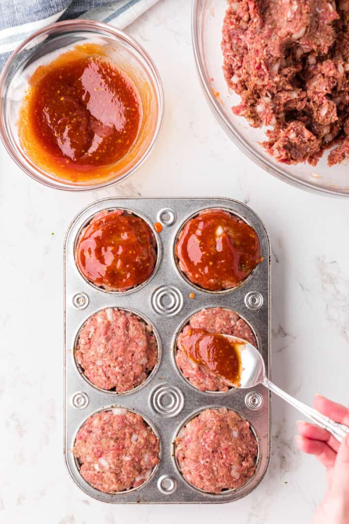 topping the meatloaf with the sauce before baking.