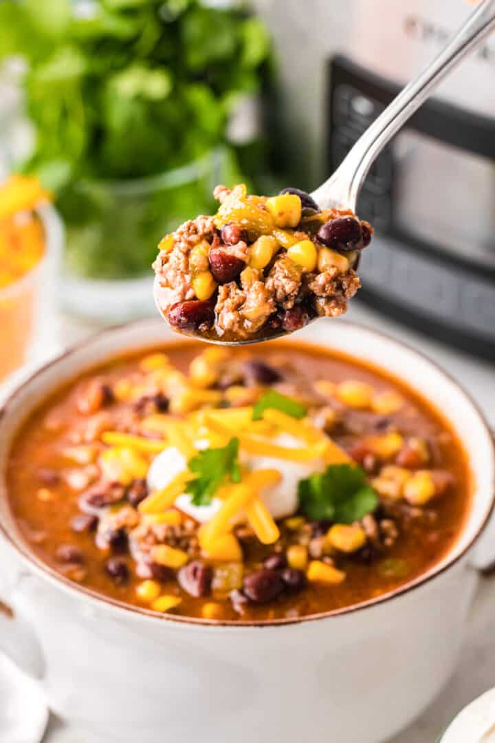 taco soup in a bowl using a spoon to eat it.