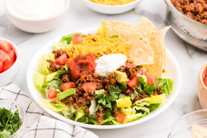 closeup of taco salad in white bowl.