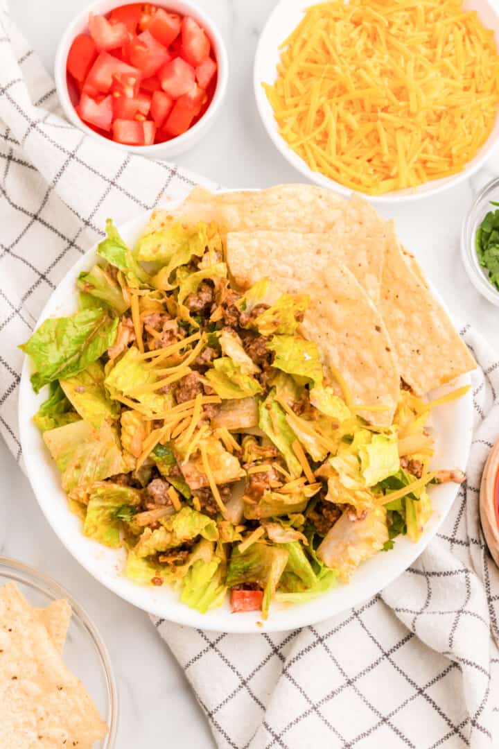 taco salad mixed in bowl with tortilla chips.