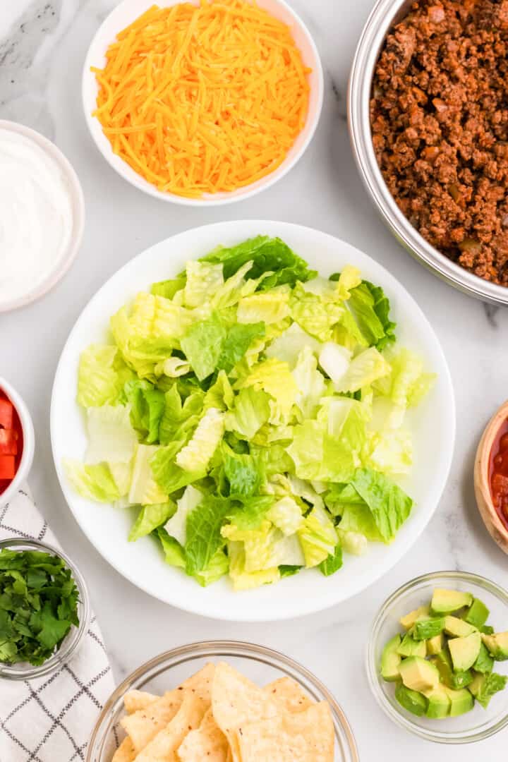 preparing the lettuce and other ingredients for the salad.