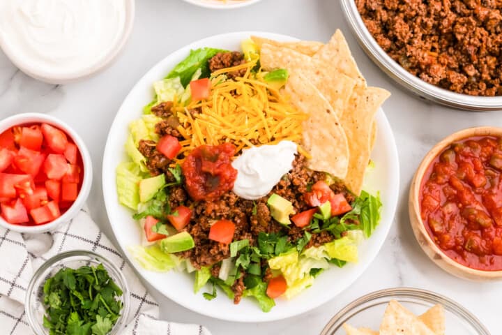 top down view of the taco salad in a white bowl.