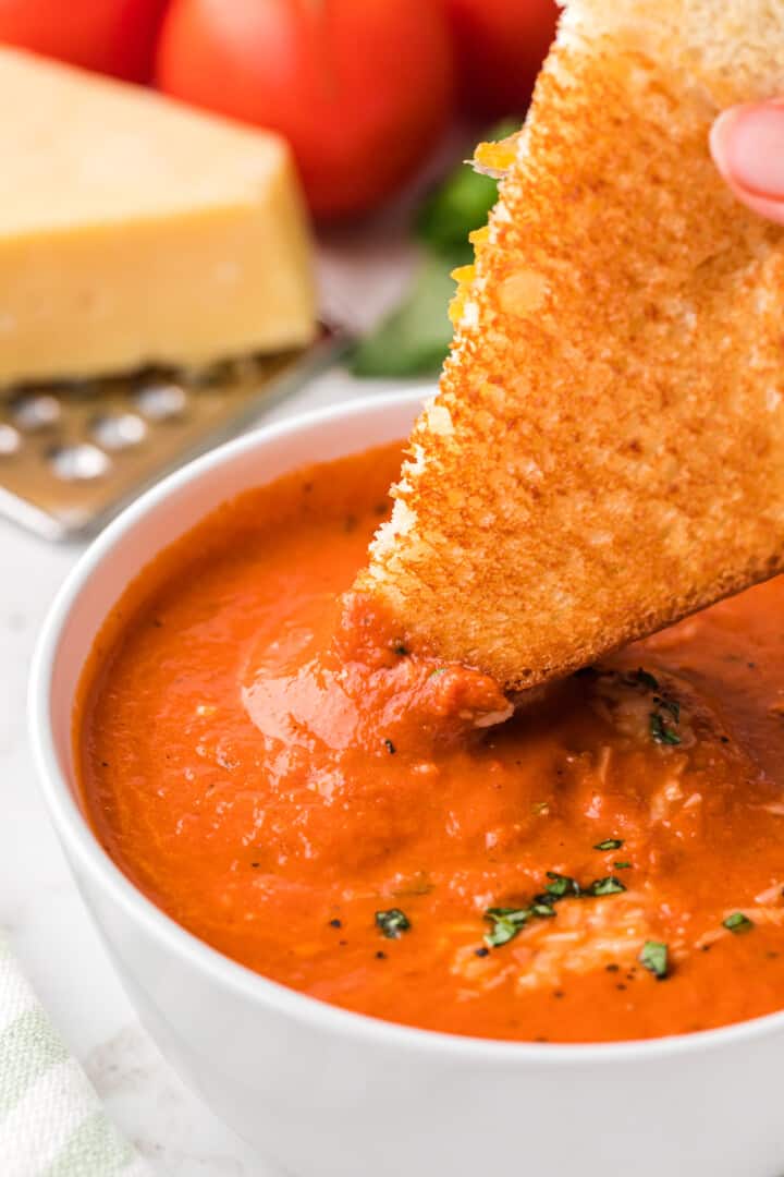 dipping grilled cheese into tomato soup.