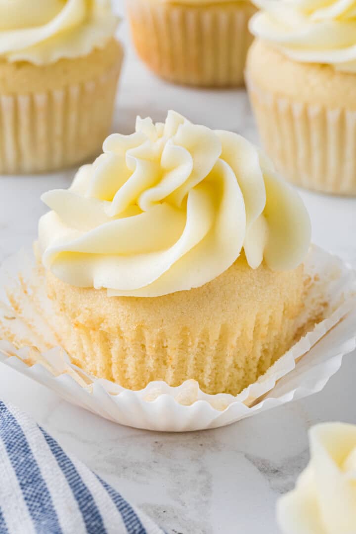 Vanilla Cupcakes on counter topped with icing.