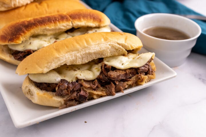 French Dip Sandwiches on white serving tray.