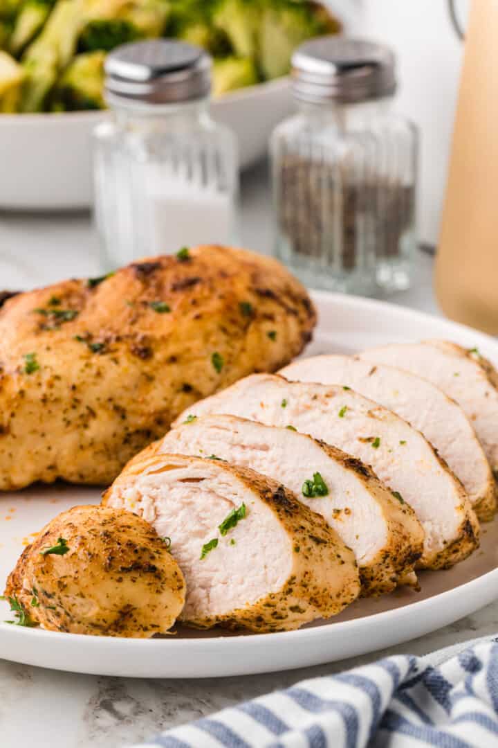 closeup of the air fryer chicken breasts on white plate.