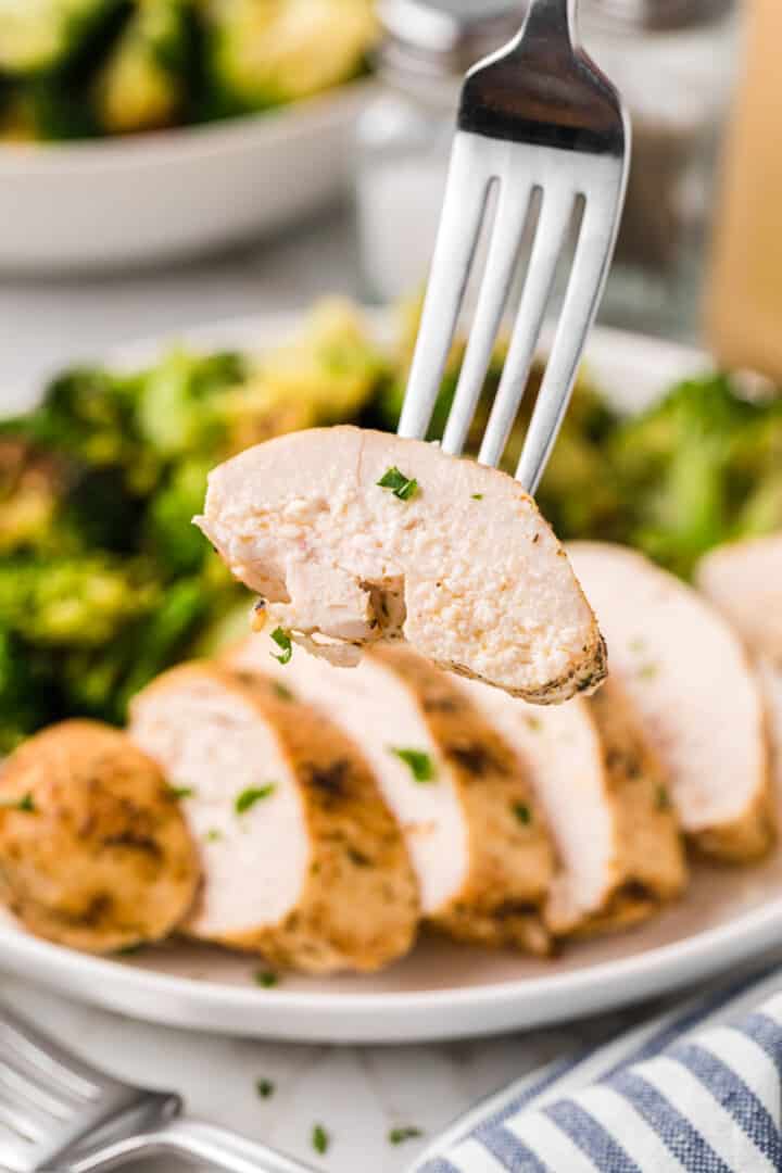 using a fork to serve a slice of the chicken.