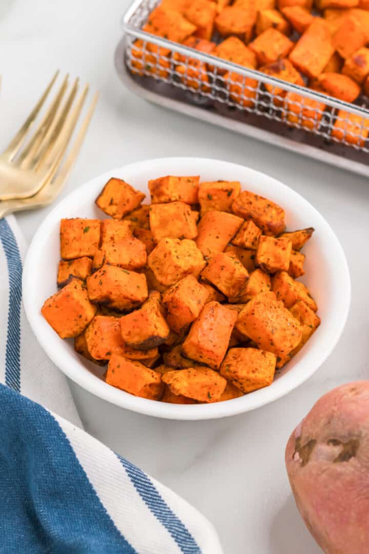 closeup of air fried sweet potatoes in white bowl.