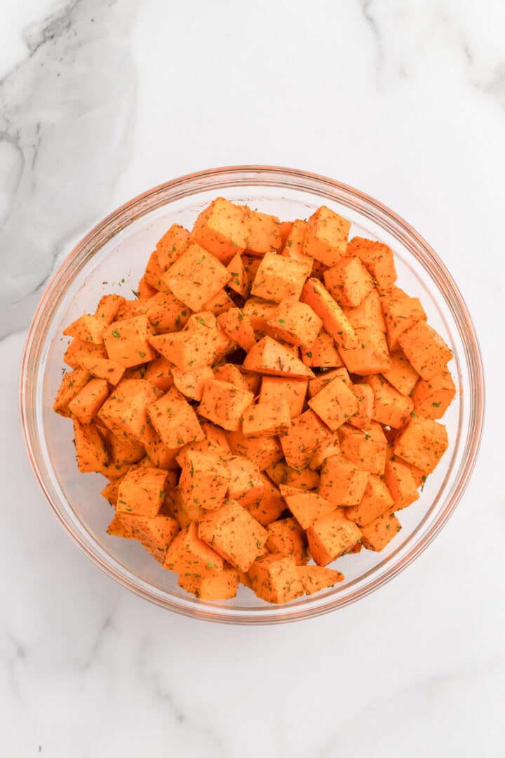 sweet potatoes seasoned in glass bowl.