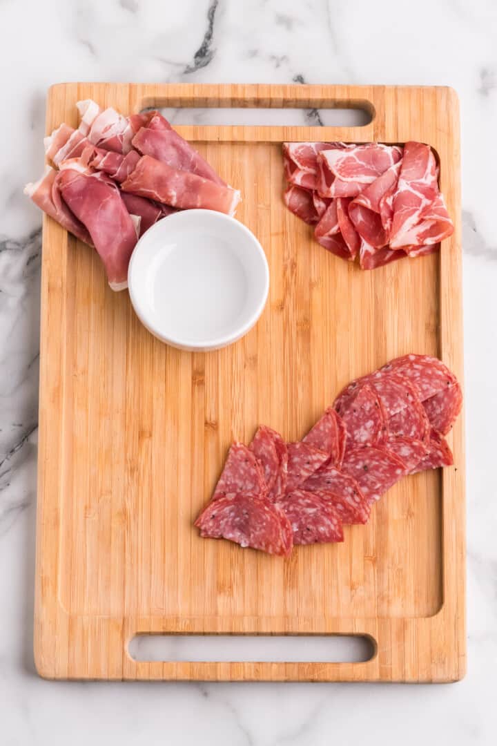 building the charcuterie board with the meats.