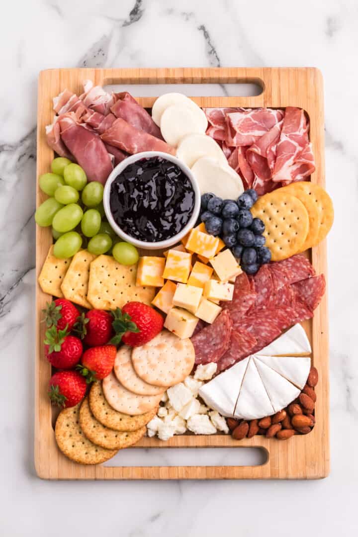 adding fruit and nuts to the charcuterie board.