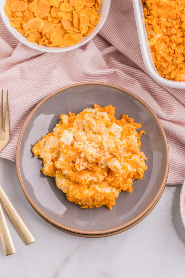 funeral potatoes served on a gray plate.