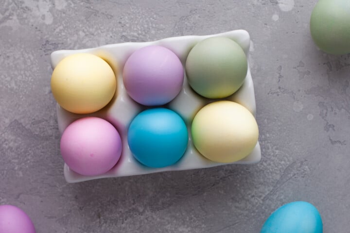 closeup of dyed eggs in white tray.