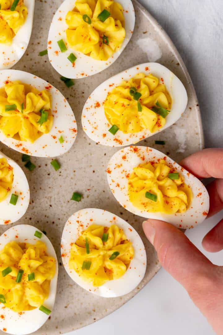 grabbing a deviled egg off the serving tray.