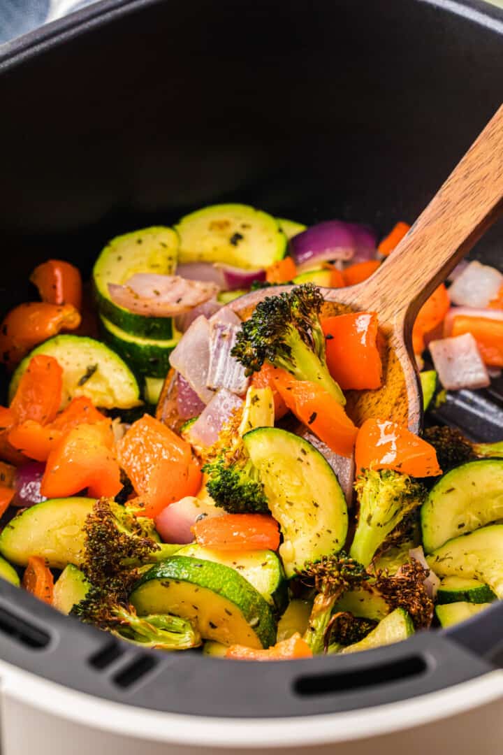 serving the air fryer with a wooden spoon.