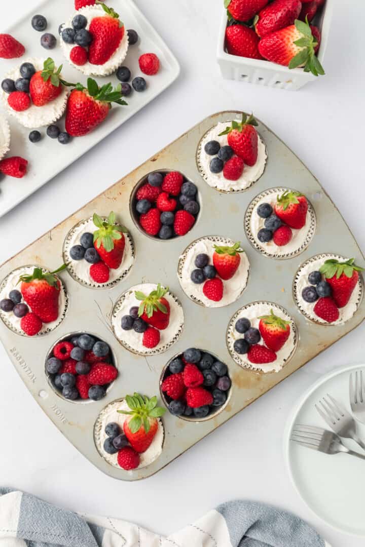 topping the cheesecakes with fresh fruit.