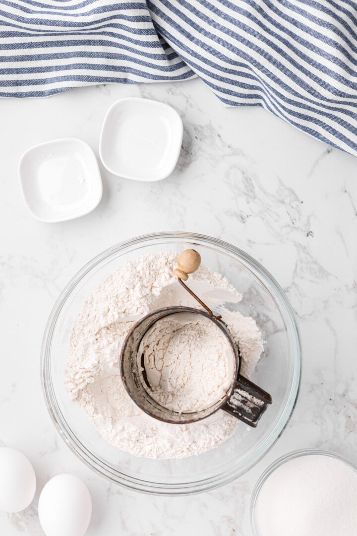 using a sifter to break up the flour.