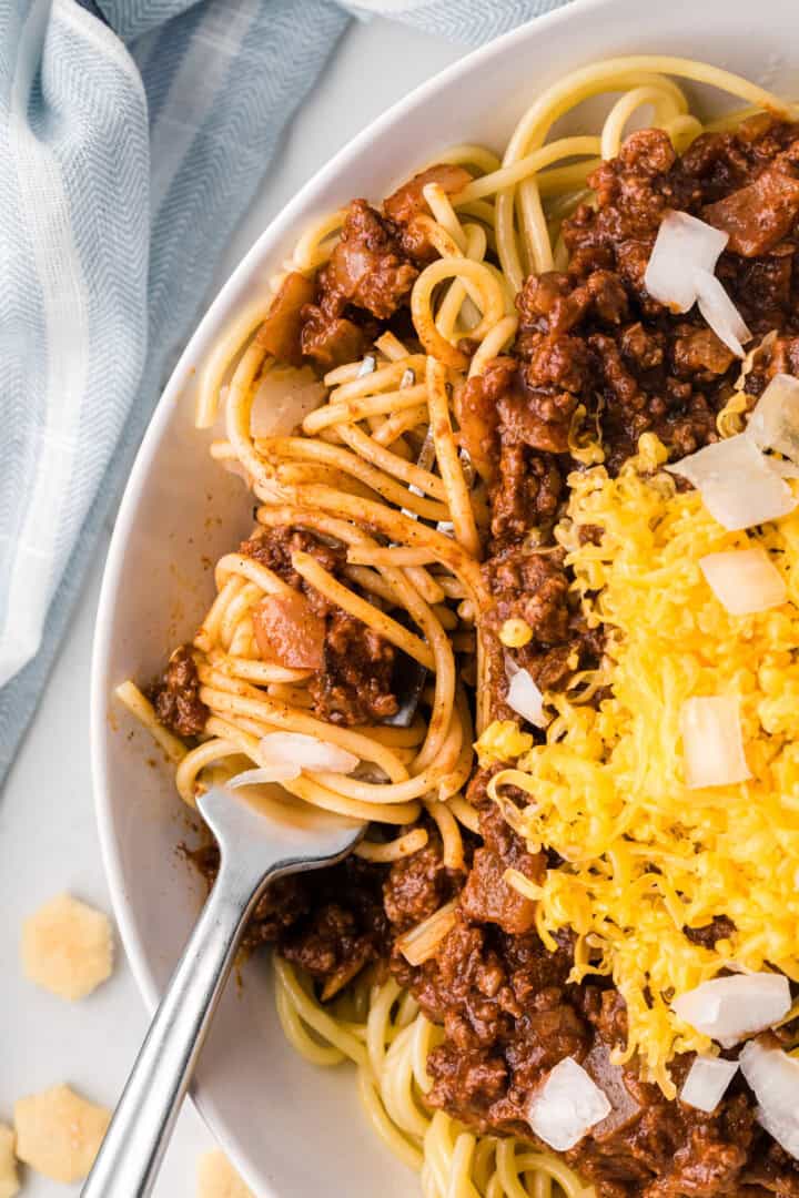 using a fork to eat the chili.