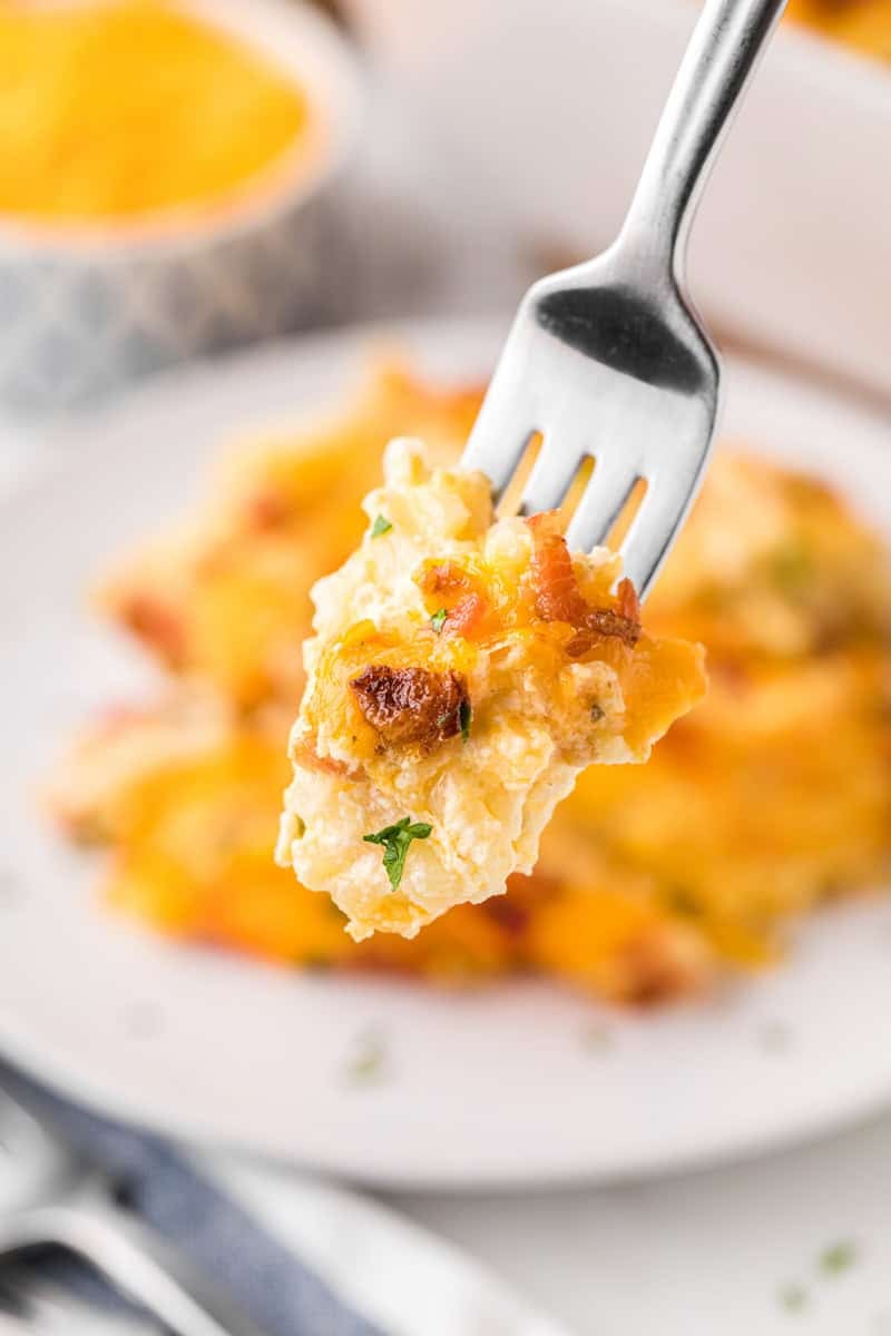 fork taking a bite of cheesy crack potatoes hashbrown casserole