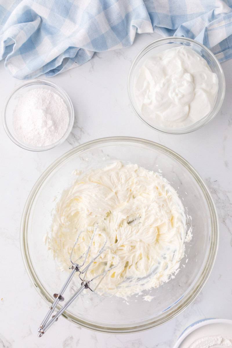 mixing the cream cheese with an electric mixer.