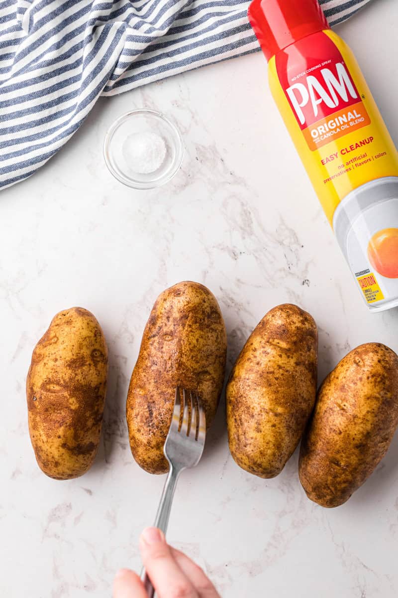 using a fork to poke the potatoes before frying.