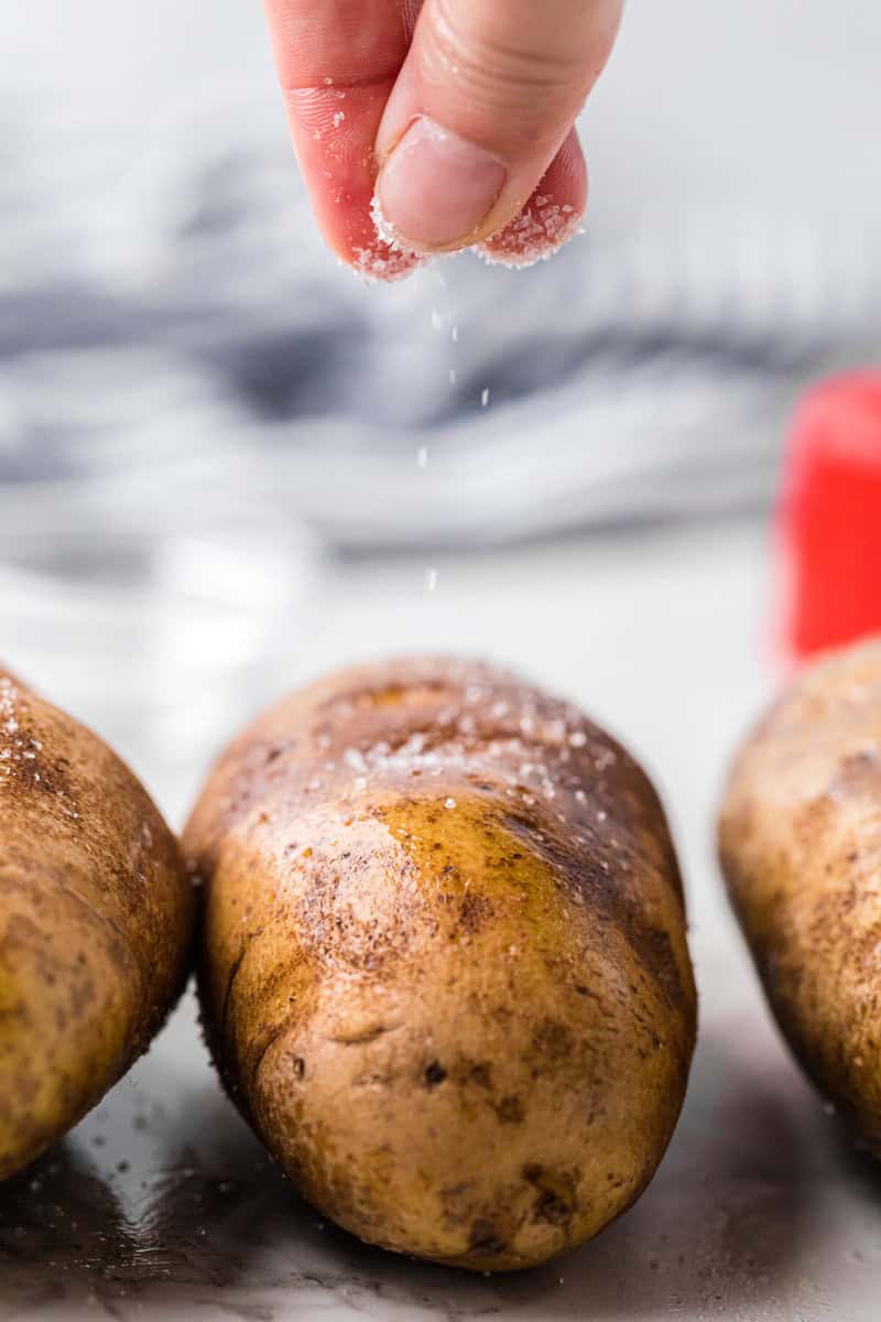 sprinkling salt on top of the potatoes.