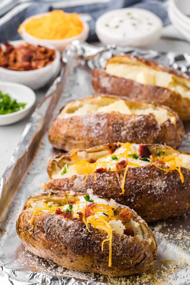 closeup of the potatoes on baking sheet loaded with toppings.