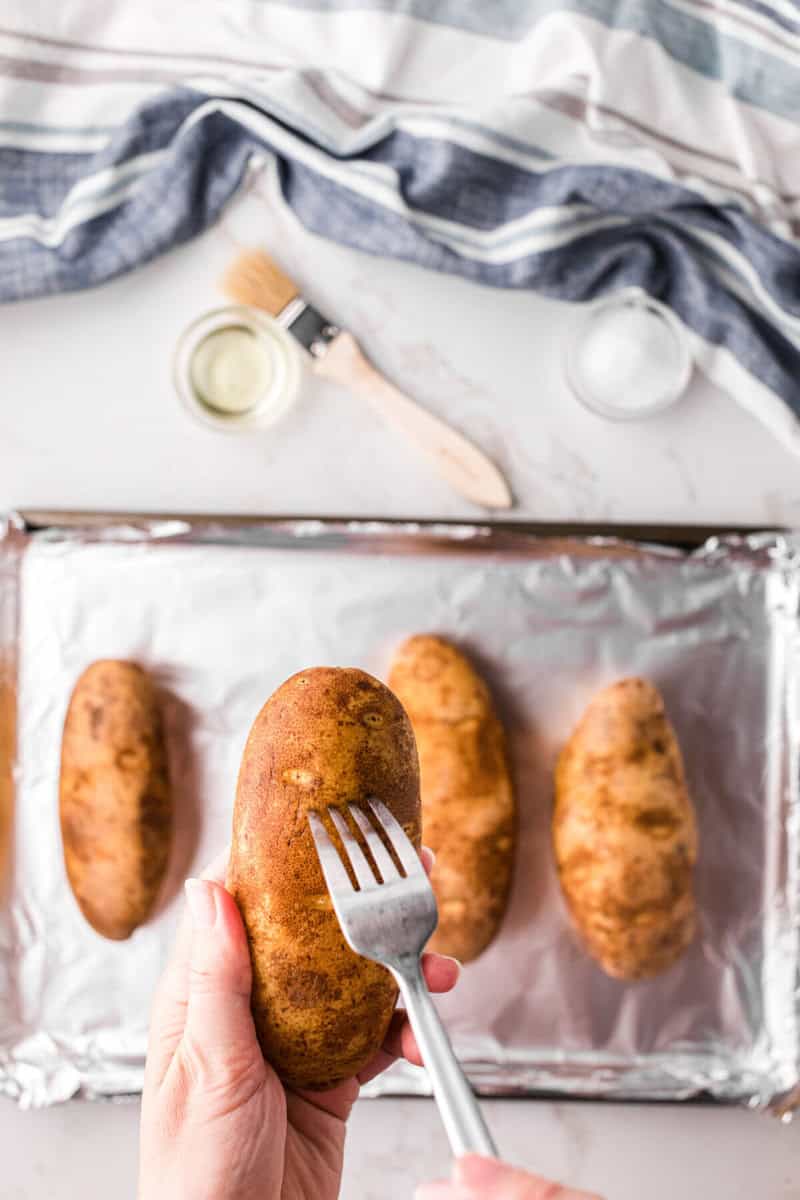 using a fork to pierce the potatoes before baking.