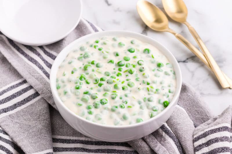 creamed peas served in white bowl.