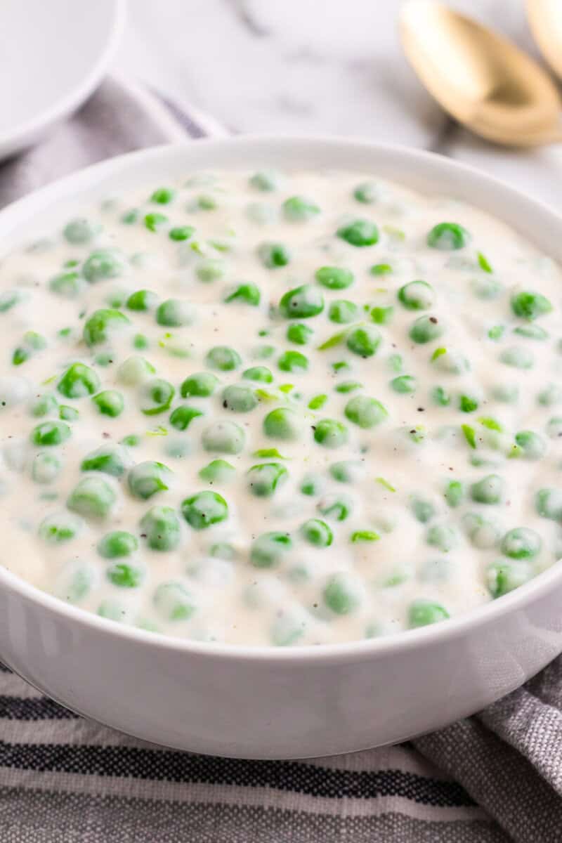 Creamed Peas being served in a white bowl.