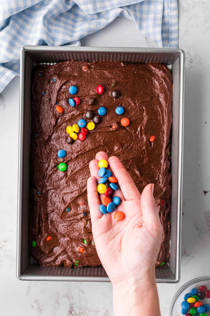 brownie batter in the pan and sprinkling more M&Ms on top of it.