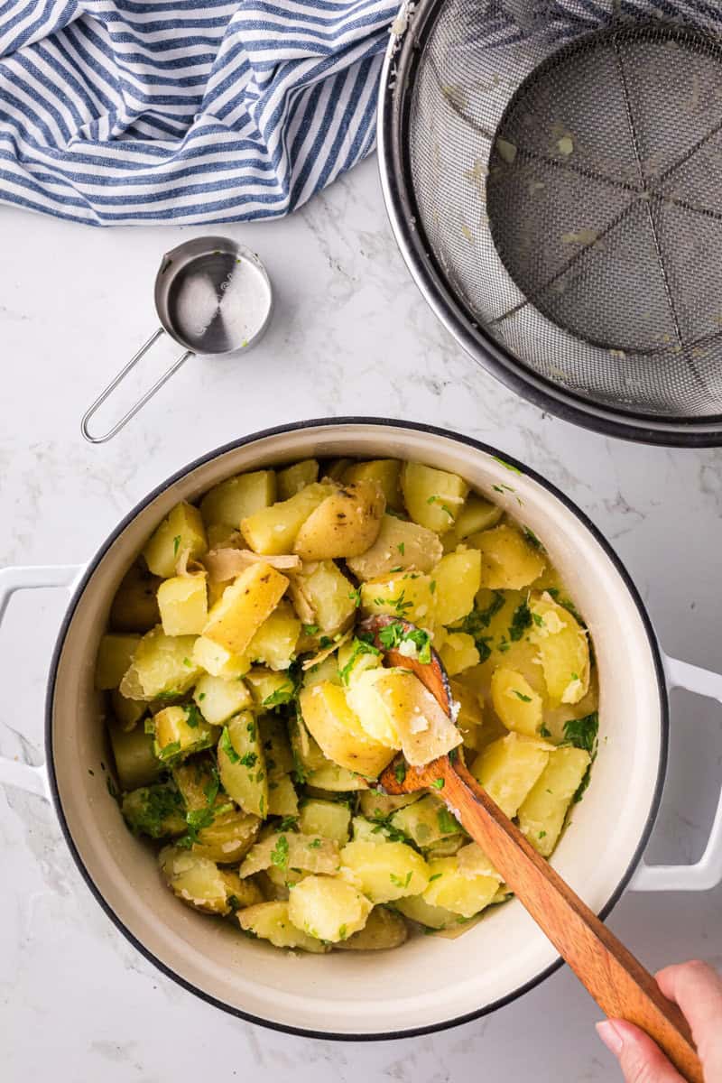 mixing the potatoes in the melted butter and parsley.