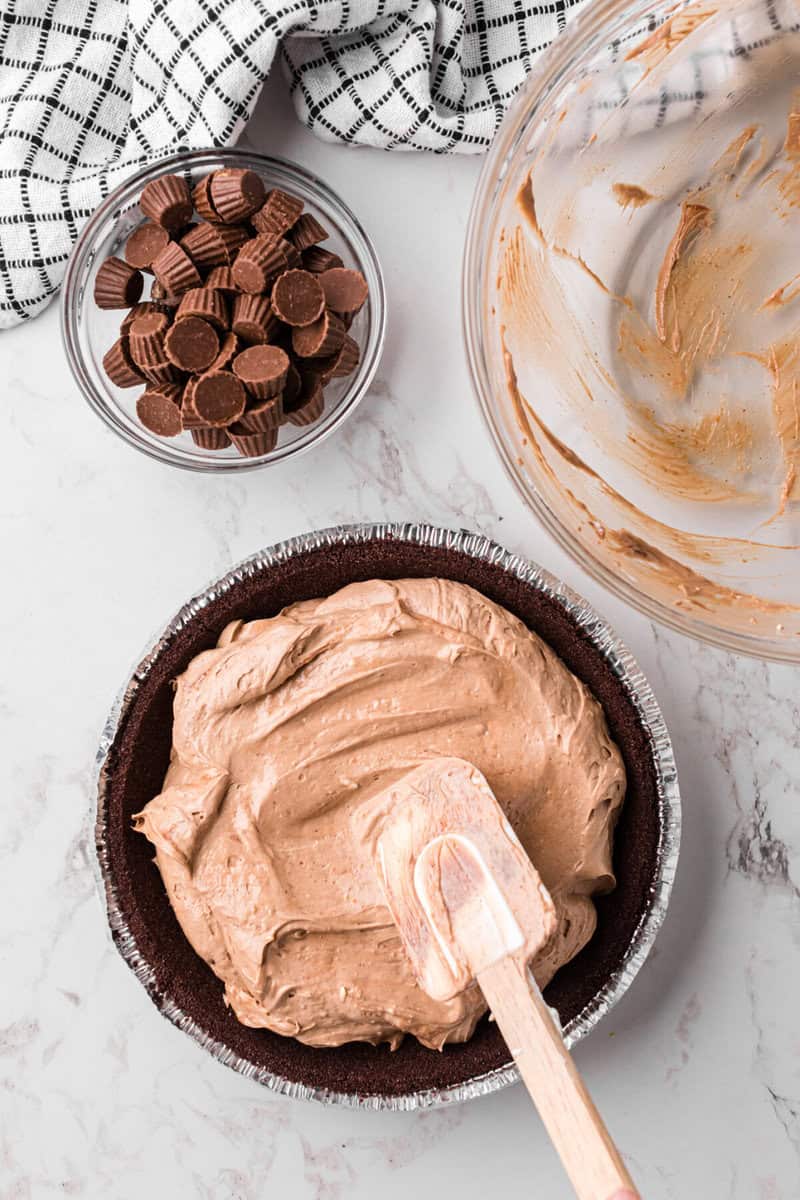 spreading the Reese's mix into the chocolate crust.